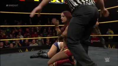 Sasha drags Alexa to the center of the ring by her blonde hair, applies The Bank Statement and refuses to let go even after Alexa taps! Poor Alexa is reduced to screaming “Ref!” for help!