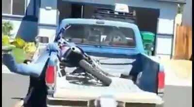 dude puts his bike on his truck, got his leg pinned.