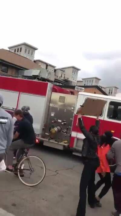 Firetruck on it's way to put out a fire is impeded by protesters