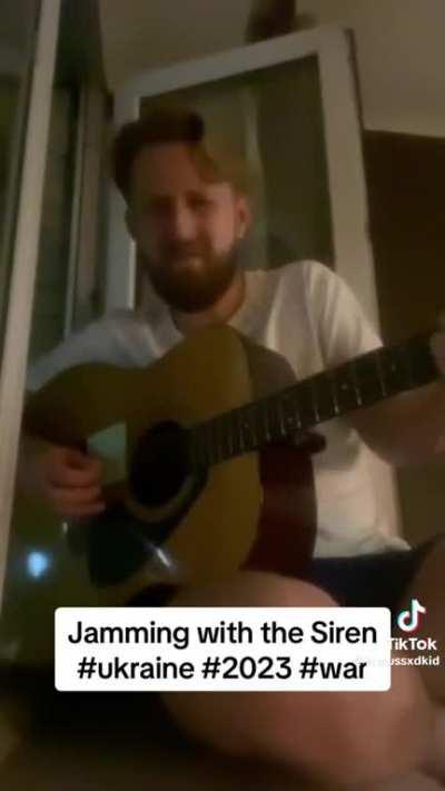 Ukrainian man plays guitar while his area is attacked by Russia