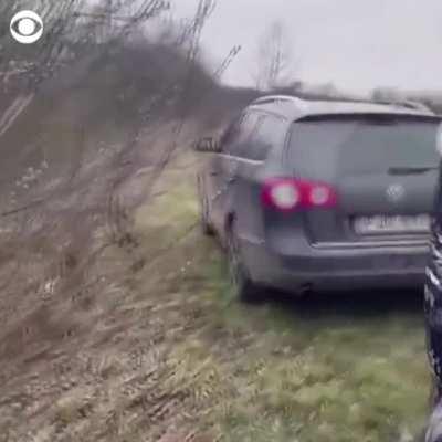 A Ukrainian mother is seen crying as she embraces her son and the stranger who brought her kids across the border to Hungary on Saturday, after her husband was forced to hand over their children and stay in Ukraine to fight.