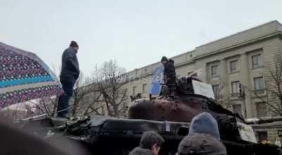 RU POV.Protestor throws Ukrainian flag from the top of RU tank placed in front of the Russian embassy in Berlin