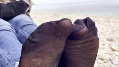 Toes wiggling in black nylon socks outdoor