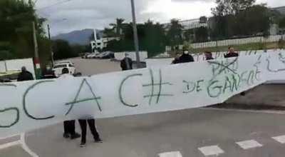 A torcida do Fluminense protestou hoje em frente ao CT. Duas faixas se destacam: 'QUEM REFRESCA CU DE GANSO É LAGOA' e 'COMO FAZ FILHO SE NÃO SABE CRUZAR' (essa aqui não tem nomes pq idealmente ofende o time inteiro)