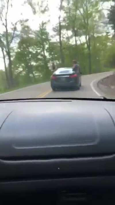 Idiot falls out of the car.