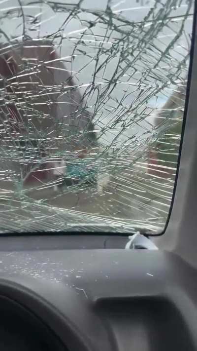 Angry woman climbs on top of car and destroys its windshield.