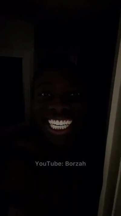 Black man smiling in dark room
