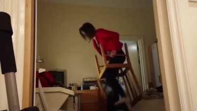 Standing on two chairs on top eachother to change the lightbulb