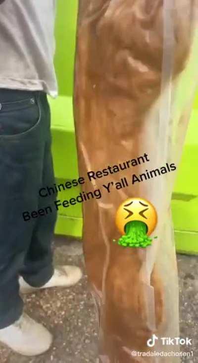 Man searches in garbage bin behind Asian Restaurant