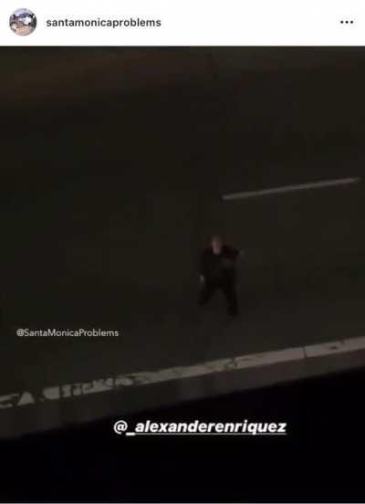 Guy screaming at a building while standing in the middle of the road