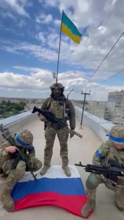 ua pov - Ukrainian troops replace flag of the occupiers on an administrative building in the center of Balakliy