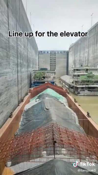 Massive transport ships make their way through a lock system