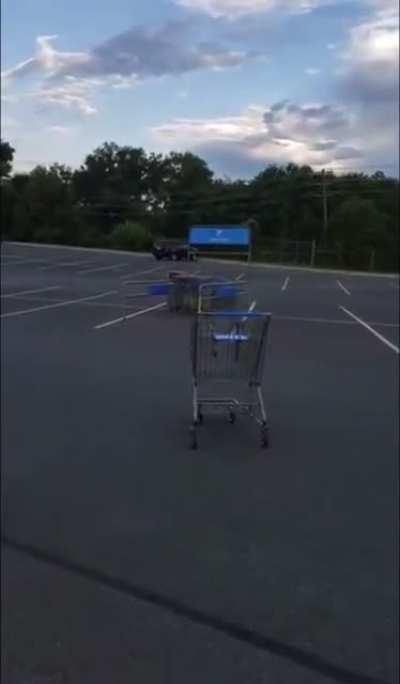 This guy dumping his cart in the middle of a parking lot.