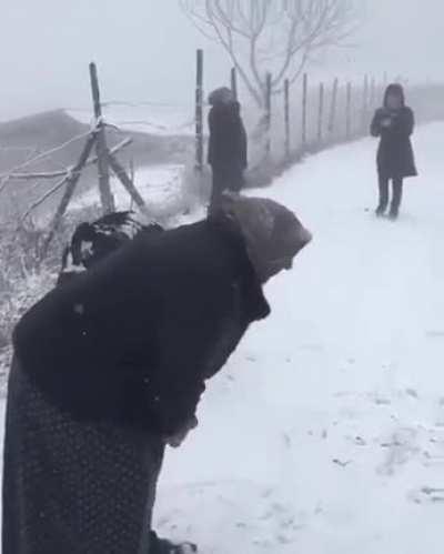 Babushkas calling for their friend to come out and play in the snow
