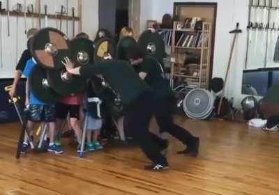 Group of students learning the strength of a proper shield wall
