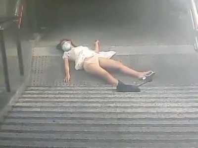 A poor Chinese girl falls from the stair because she keeps looking at her phone, and no one is helping her