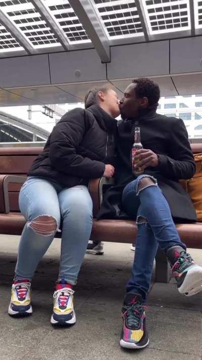 Black man kissing a white woman in public