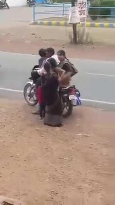 People getting on a 2 wheeler in India