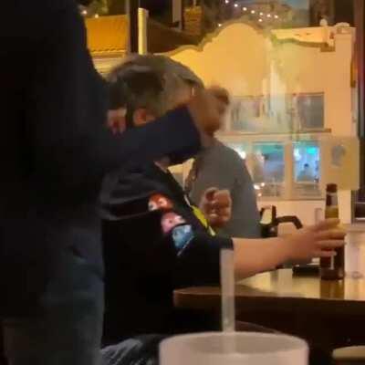 Woman screams at table because one person is wearing a MAGA hat