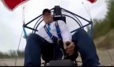 Man hits a tree while using a parachute aircraft.