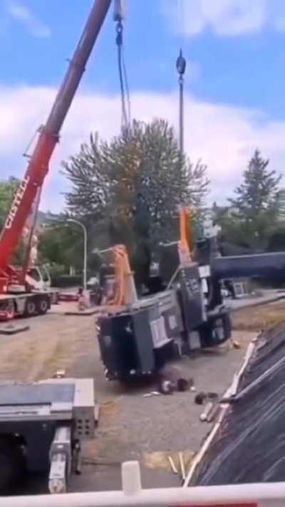Standing under a large metal item being hoisted by a crane
