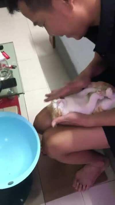 Деда и его ассистент показывают как купать младенца.