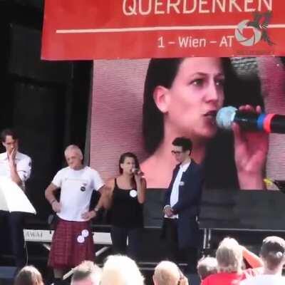 „Querdenken“-Aktivisten zerreißen Regenbogenflagge auf der Bühne in Wien