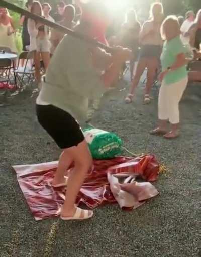 Standing in front of a blindfolded person trying to hit a piñata