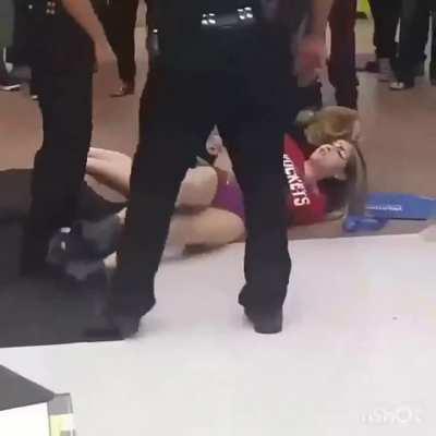 Two girls protesting getting removed from shopping mall