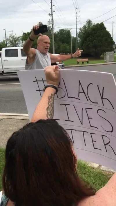 Man freaks out at peaceful protesters and accuses them of being paid to protest.