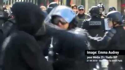 to grab a riot cop's weapon