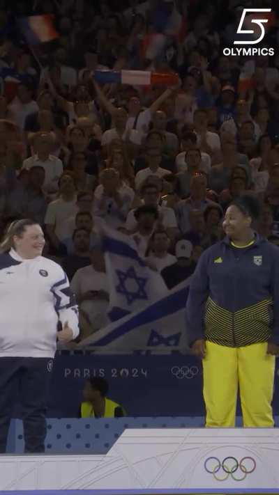 Cute Olympic moment +78 judo silver madalist Raz Hershko (ISR) encourages gold medalist Beatriz Souza (BR) to smile ar the podium.