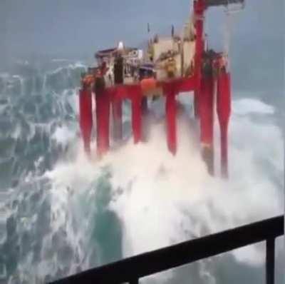 Massive waves hit an offshore oil rig