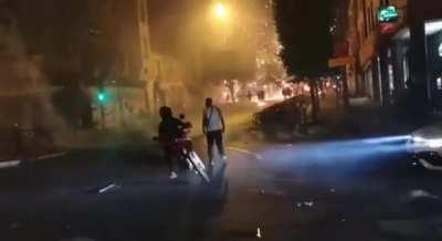 A guy makes a little jump to avoid getting hit by a chainsaw dragged by a motorcycle.