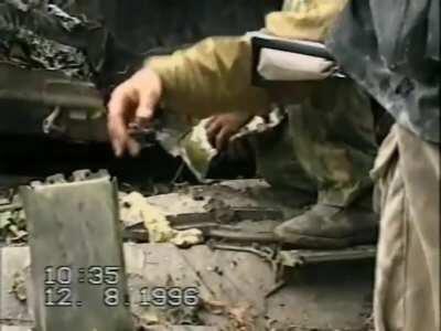[Chechnya] Russian Soldiers extract the body of a tank crewman out of a T-72 after an armor column was ambushed on the outskirts of Grozny. August of 1996. *NSFW*