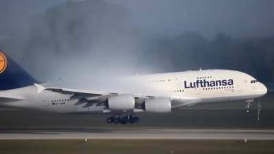 The A380 lands smoothly, framed by a dramatic vapor cone
