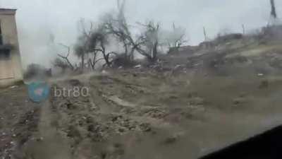 A Ukrainian vehicle unknowingly drives behind a Russian Tank that is firing in the other direction.