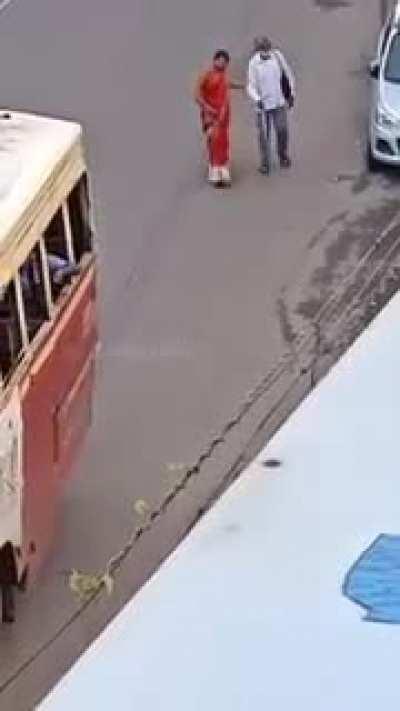 A woman helping a blind man to catch the bus.