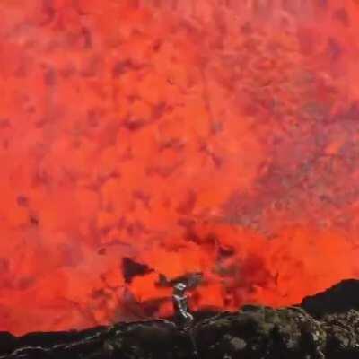 A man inside the crater of an active volcano.
