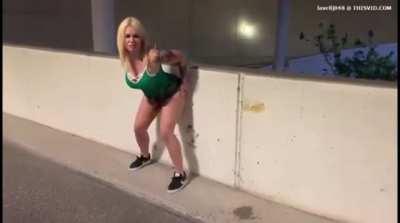 Woman rubbing her dirty ass on the wall of a parking structure