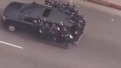 Cop falls off truck, pepper sprays the offending air.