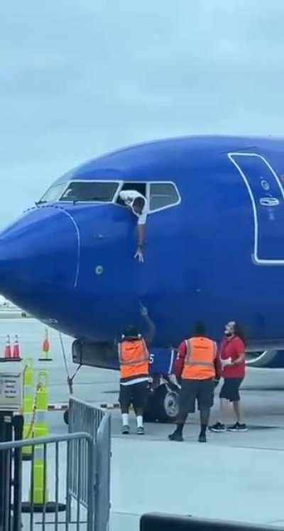 Ground staff help return a passenger’s phone found near the gate after the plane had closed its door