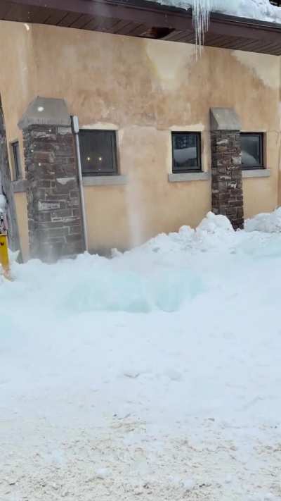 Removing ice from a Canadian roof.