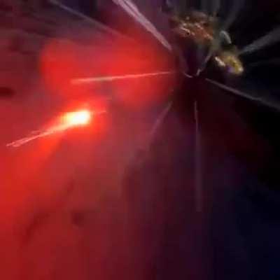 Man ties some sort of flare gun to his feet and jumps off a cliff in a wingsuit looking like a comet.