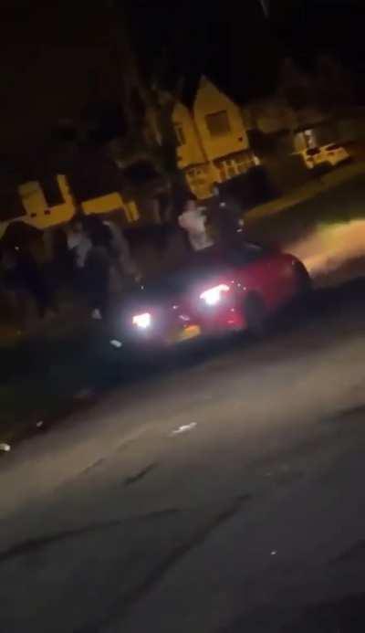 Guy nearly gets his head crushed by a car after it crashes and flips into him