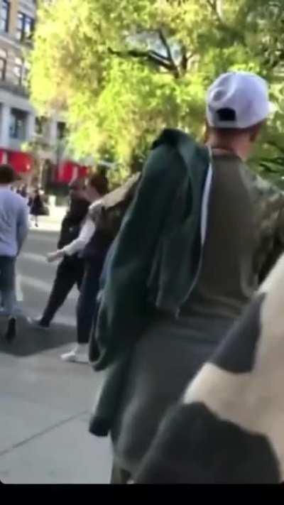 Racist lady spits on food vendor and yells racial slurs on a busy sidewalk