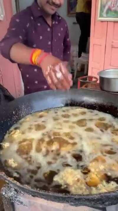 Casually dipping hand in boiling hot oil