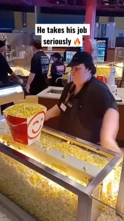 The way this concession clerk serves popcorn