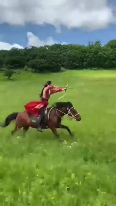 Archer shooting 3 targets, while riding a horse