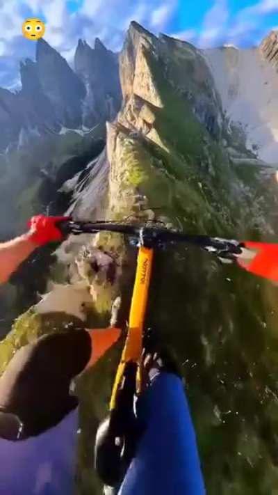 This man goes downhill on his bycycle